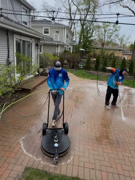 Our crew cleaning a paver patio with a surface cleaner