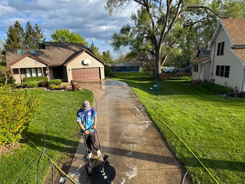 Our crew cleaning a concrete walkway with a surface cleaner